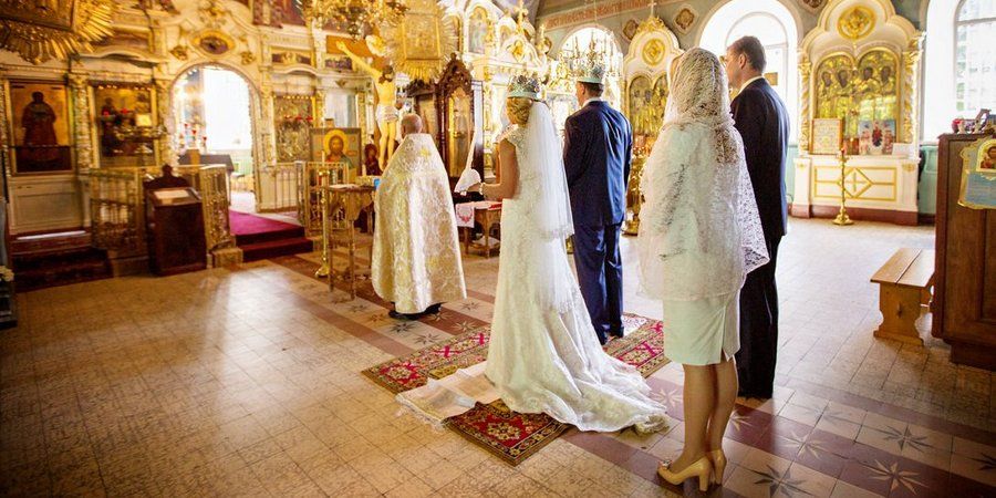 Священнослужитель проводит мужа и жену в центр храма